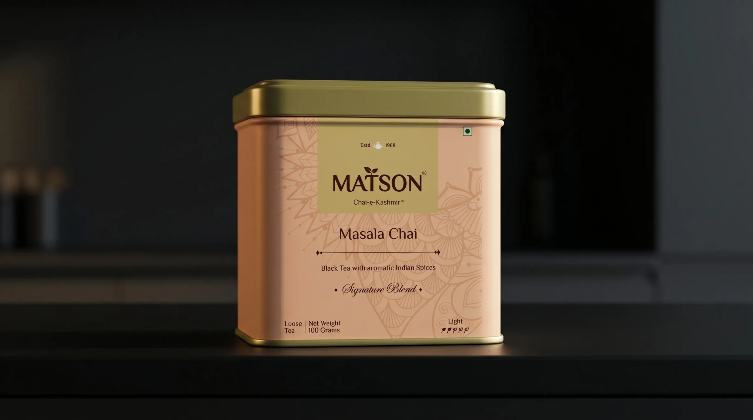 Matson Masala Chai tea tin with a gold lid on a dark shelf; peach-colored canister featuring Masala Chai text and decorative patterns.