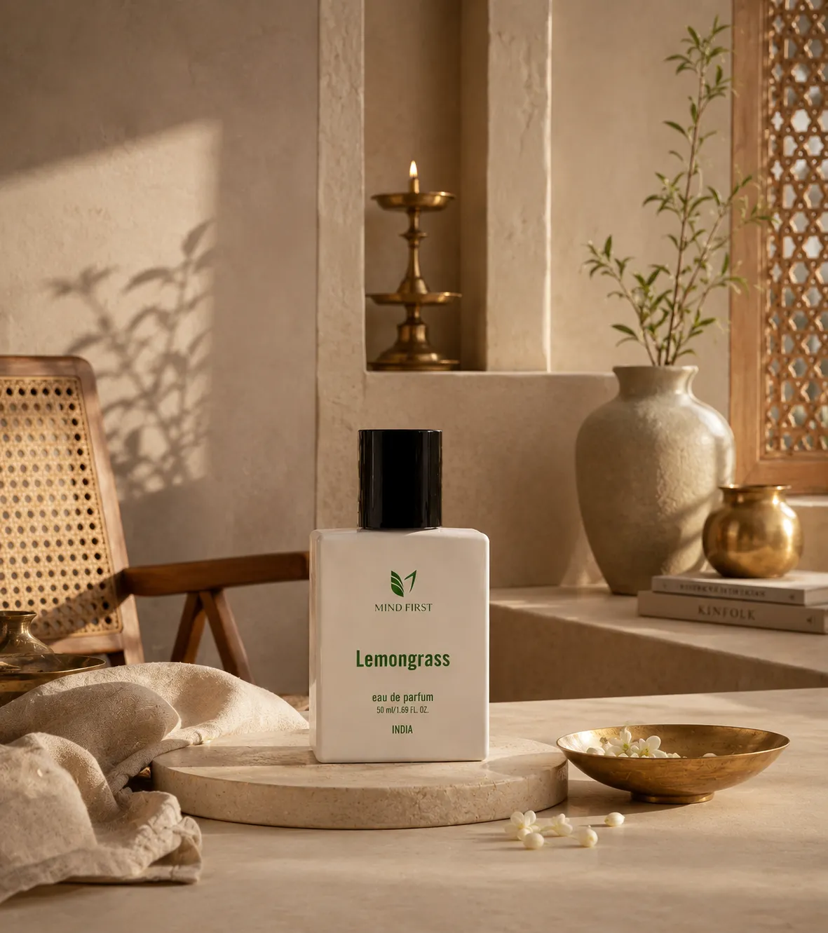 Mind First Lemongrass perfume bottle on a neutral marble table, with warm decor including a vase and golden bowls in soft sunlight.