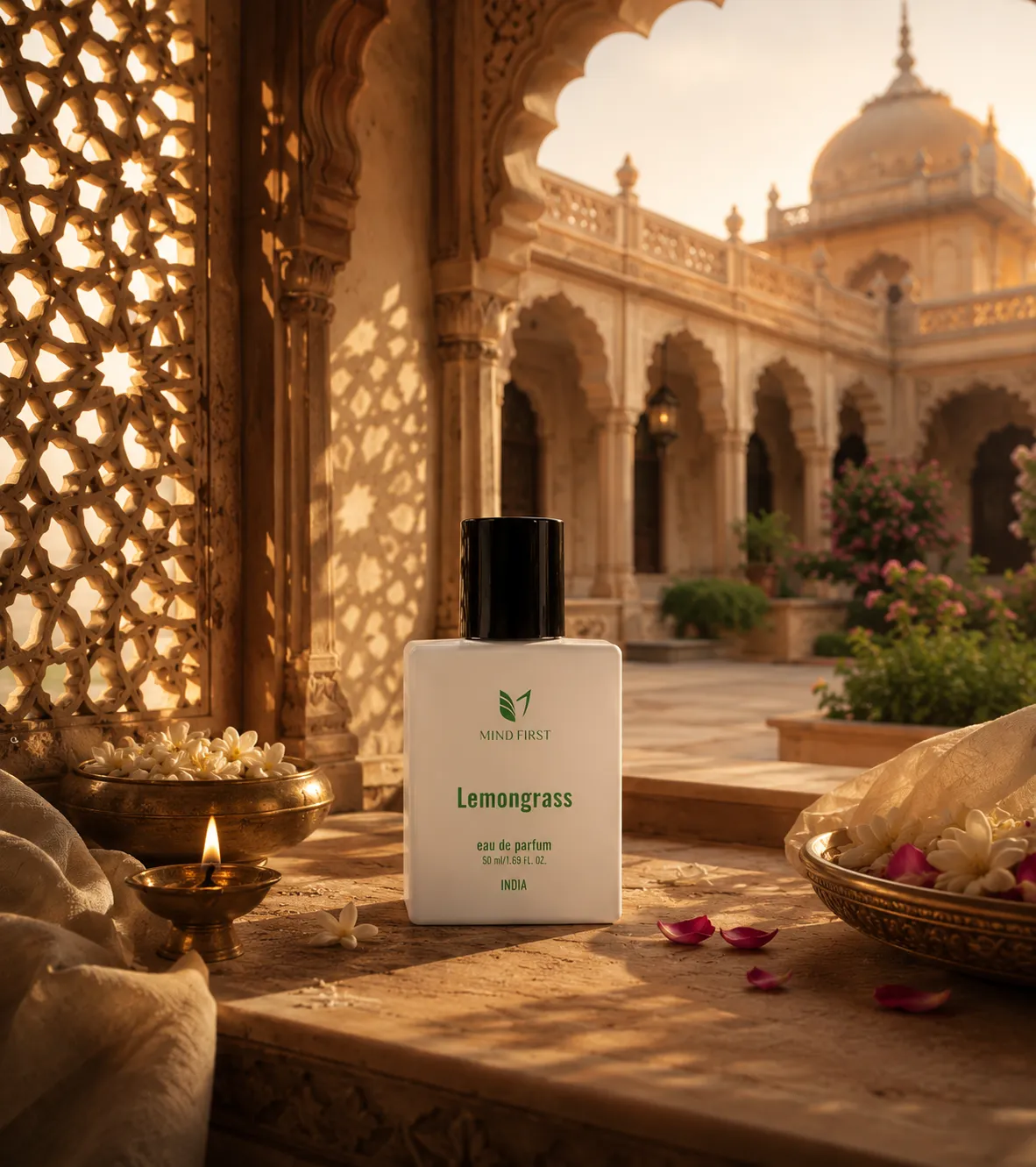Fragrance bottle labeled Lemongrass by Mind First on a stone ledge in a sunlit Indian courtyard with ornate arches and petals nearby