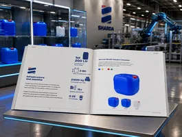 Open product brochure on a display stand at a trade show, featuring blue cube containers and smaller matching vessels with SHARDA branding in the background.