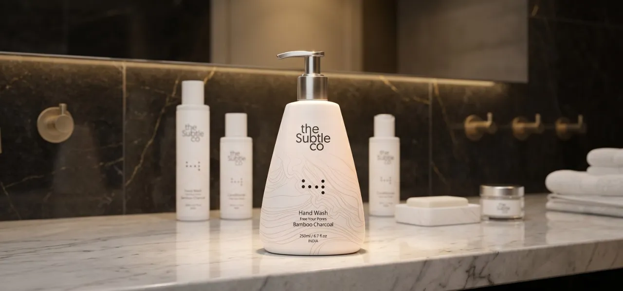 Front white pump bottle of The Subtle Co hand wash on a marble bathroom counter.